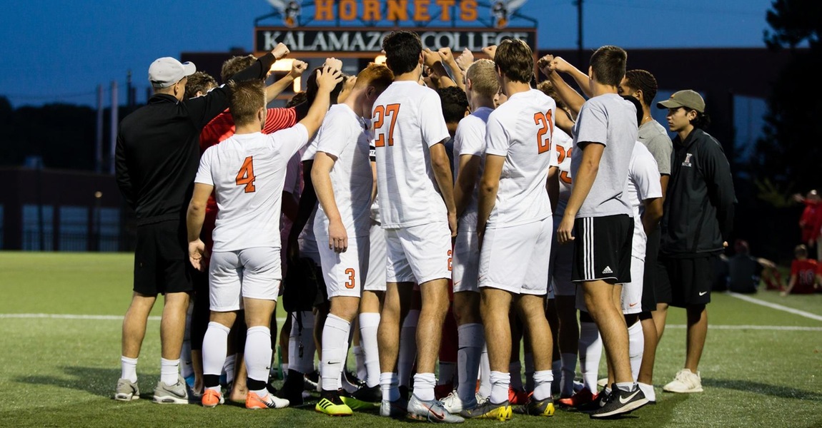 The Kalamazoo College men's soccer team in a huddle.