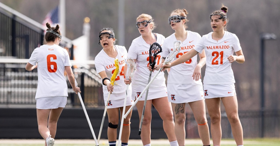 The Kalamazoo College women's lacrosse team celebrating after a goal.
