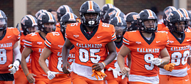 The Kalamazoo College football team running on to the field.