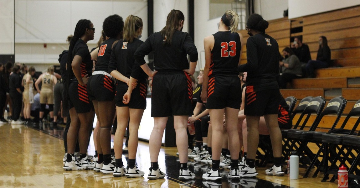 The Kalamazoo College women's basketball team in a huddle.