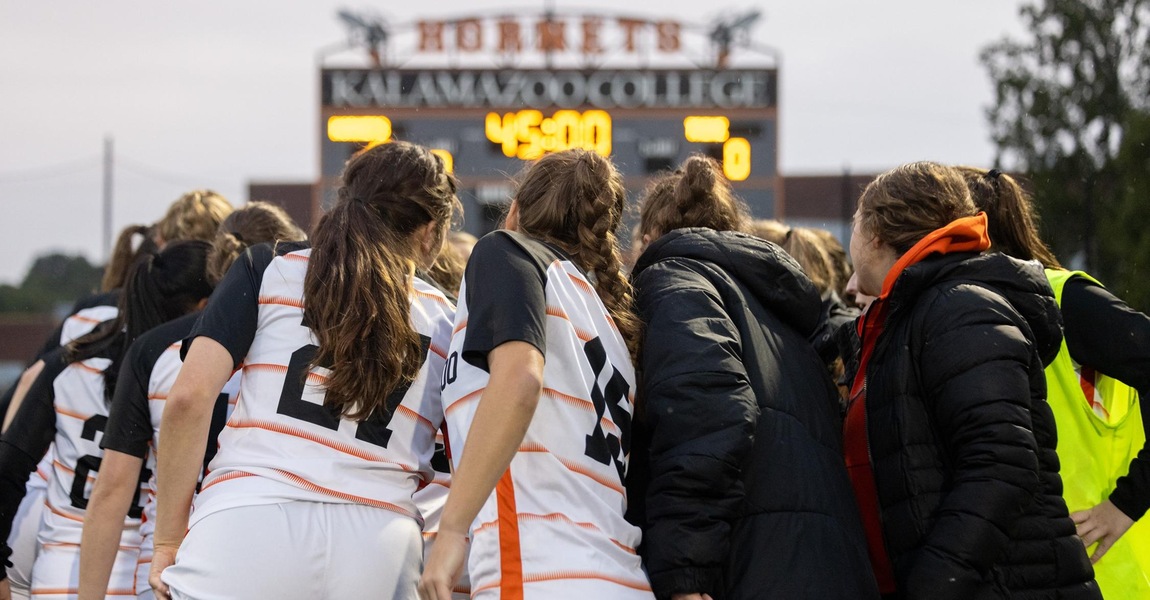 The Kalamazoo women's soccer team in a huddle before the game.