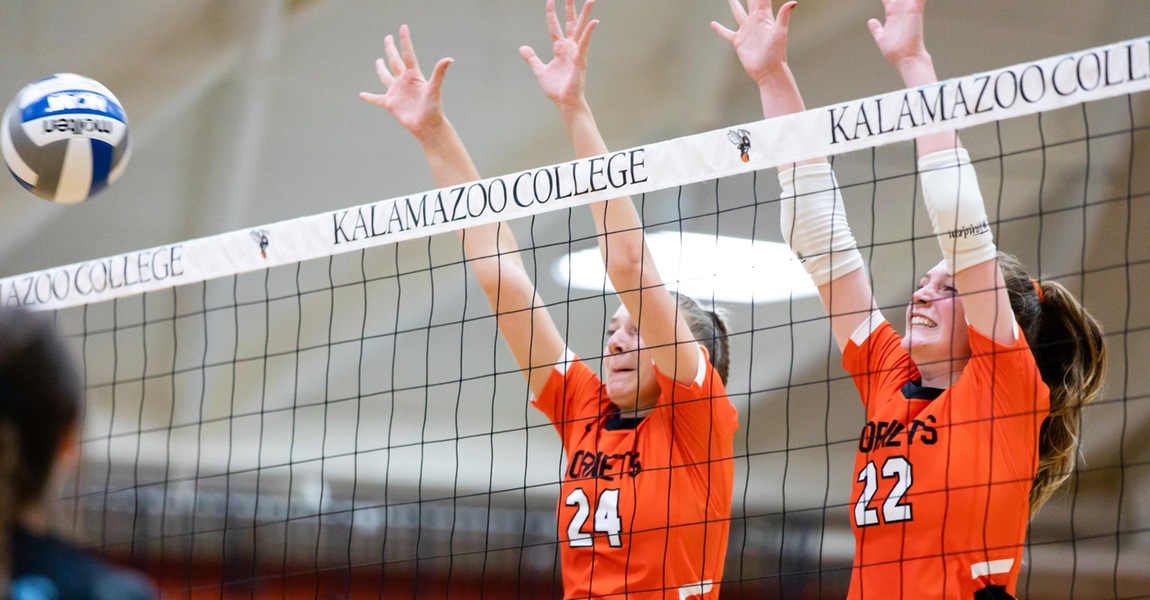 Toni Koshmider and Halley Johnson blocking a volleyball at the net.