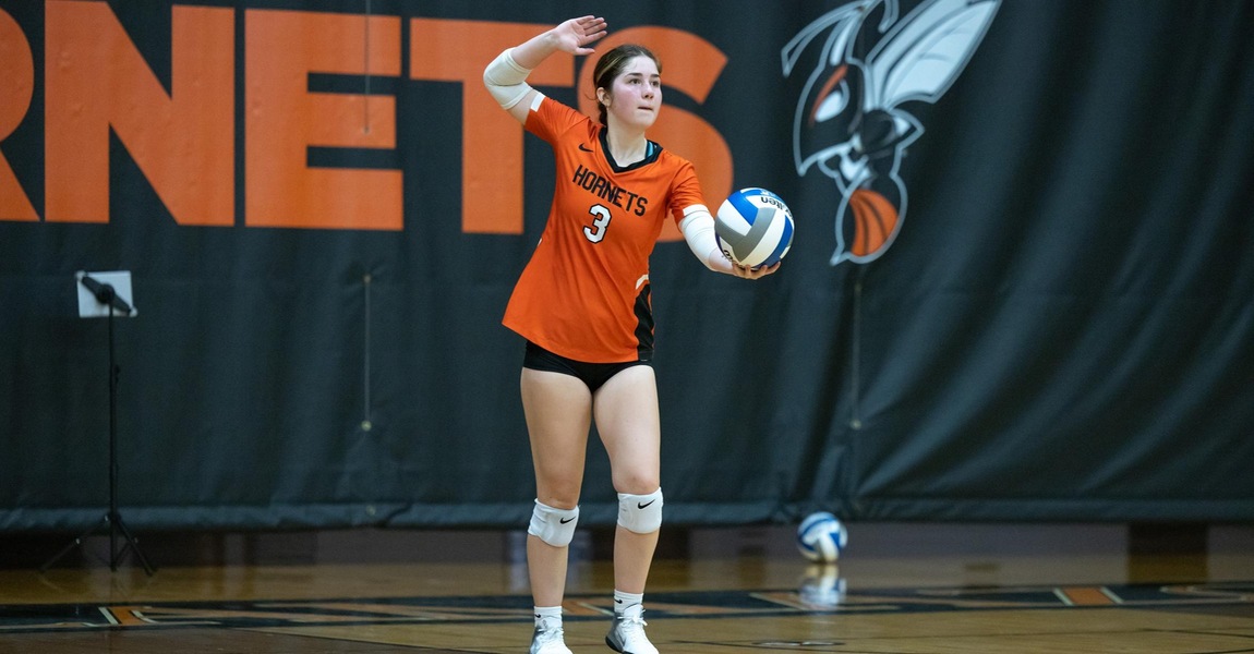Sara Reathaford serving a volleyball.